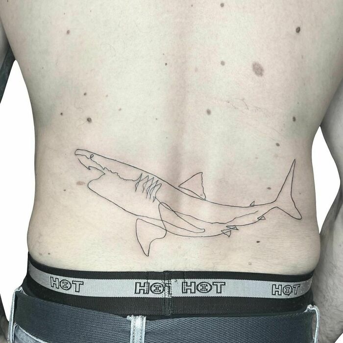 Single line shark lower back tattoo