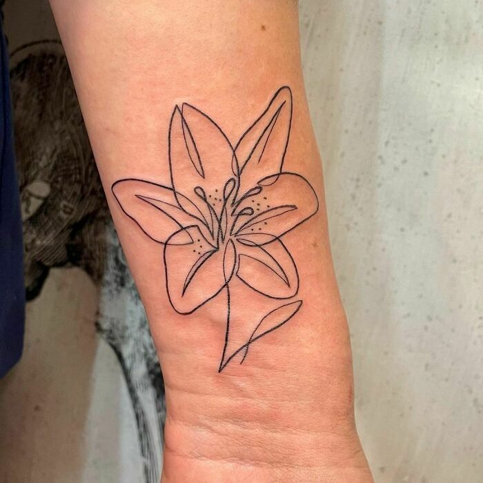 Single line lilly flower wrist tattoo