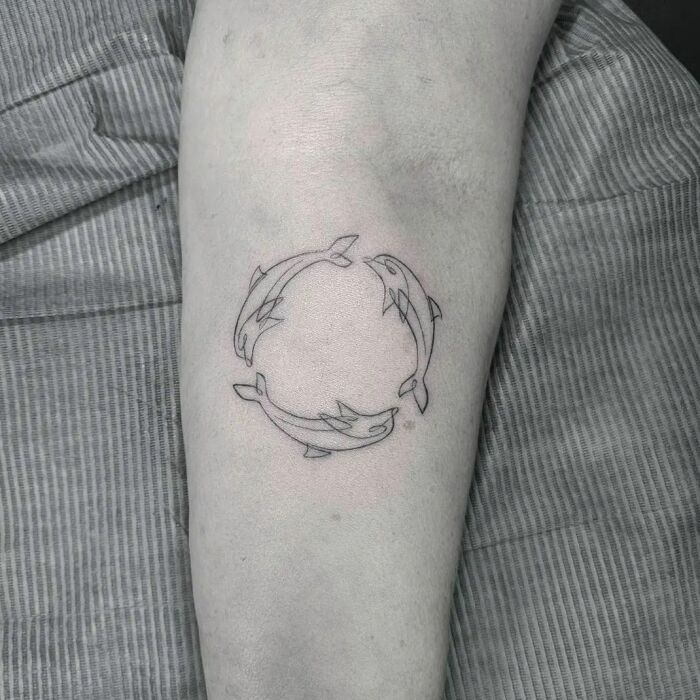 Single line circle of dolphins tattoo