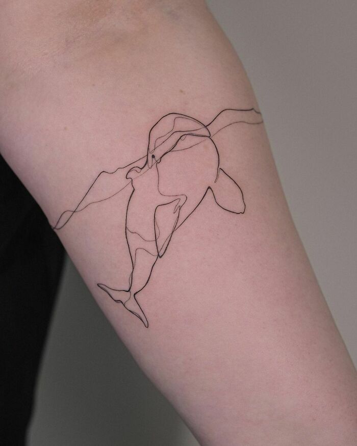 Single line swimming whale tattoo