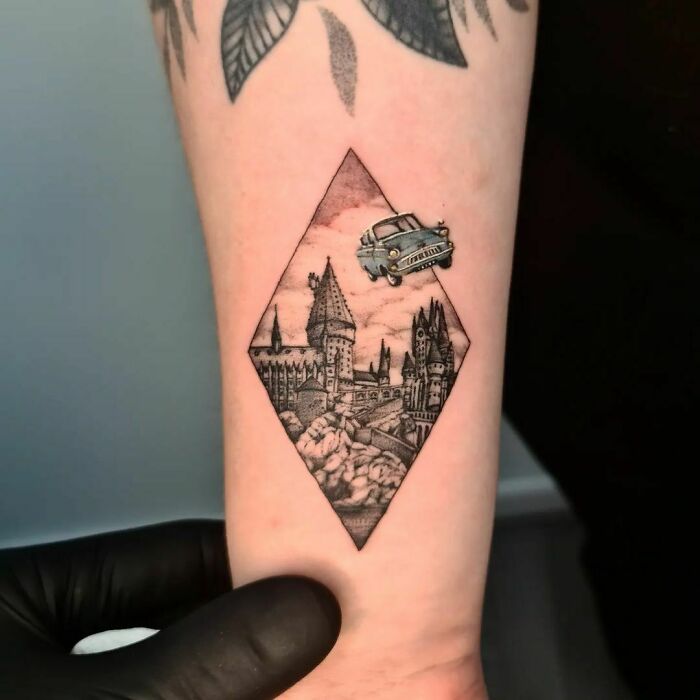 Harry Potter tattoo of Hogwarts with flying car on forearm, showcasing detailed inkwork for fans of the Wizarding World.
