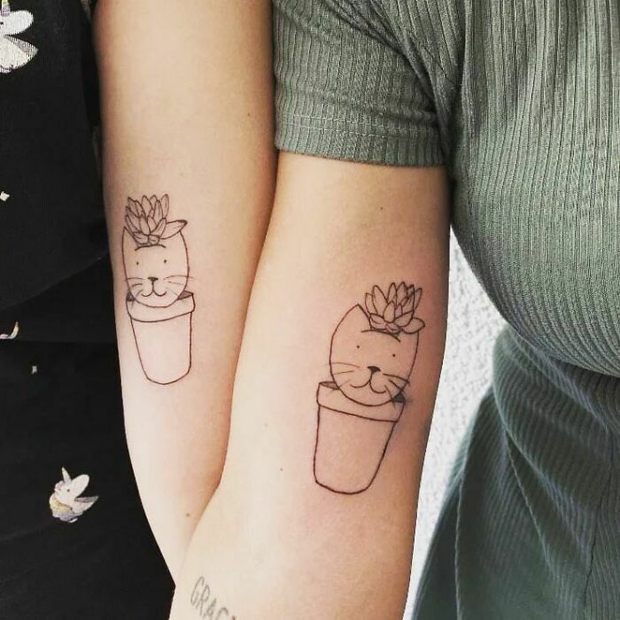 Two best friend tattoos of a cat with a plant on its head, symbolizing lasting friendship.