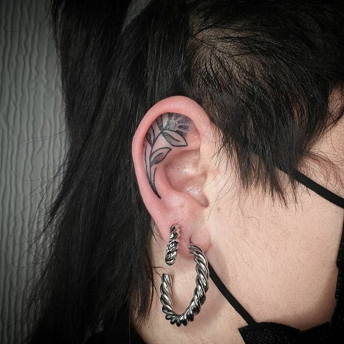 ear tattoo of a flower and leaves