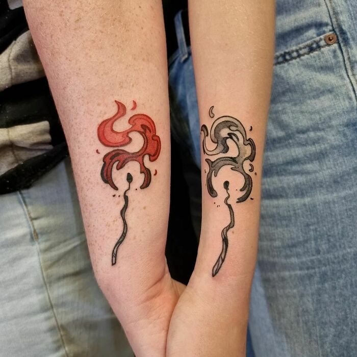 Matching abstract ink designs on two forearms, symbolizing best friend tattoos in red and black.