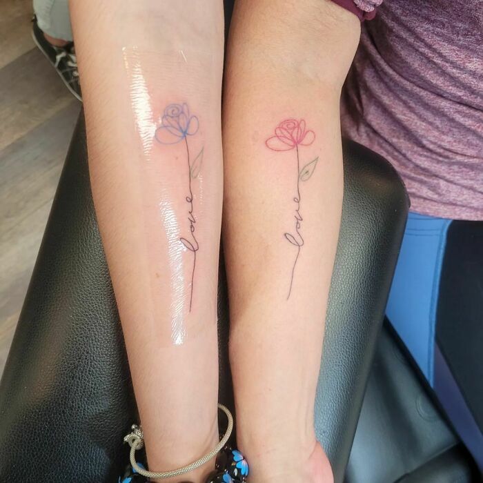 Matching single line colorful rose arm tattoo