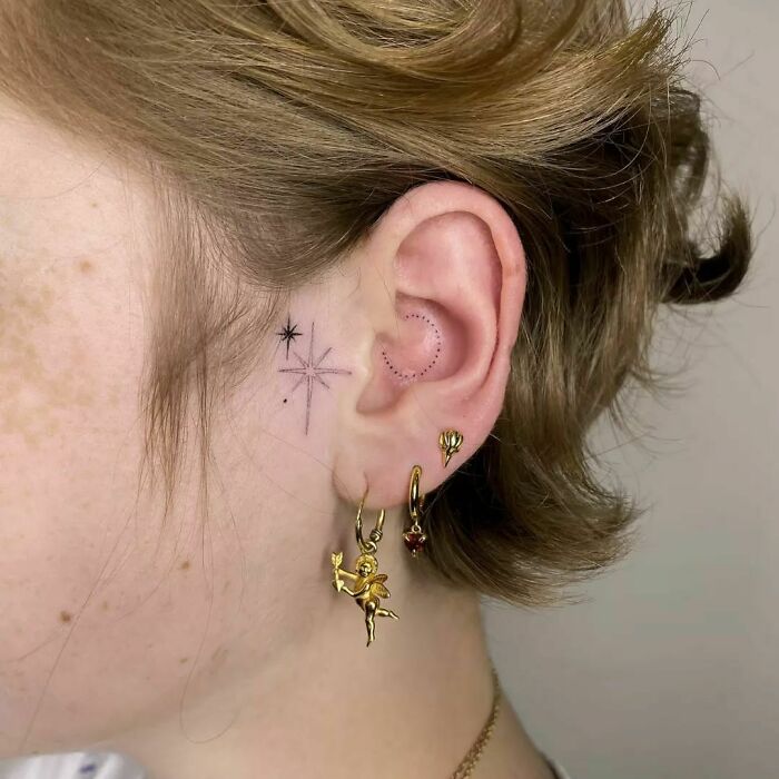 ear tattoo of a star and dot circle