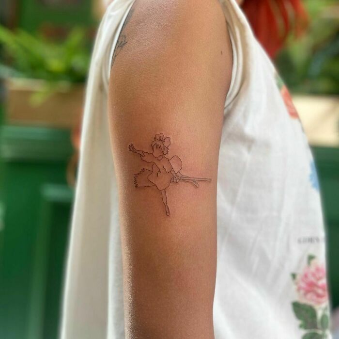 Line Kiki on her broom arm tattoo