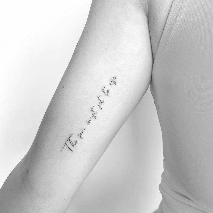 Minimalist word tattoo on arm with phrase “The sun must set to rise.”