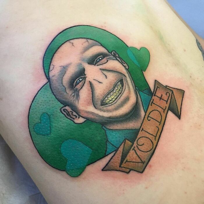 Tattoo of a character from Harry Potter with green hearts and a ribbon reading "Voldie."