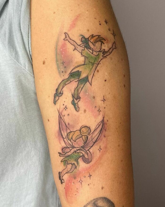 Graphic Peter Pan and Tinker Bell arm tattoo
