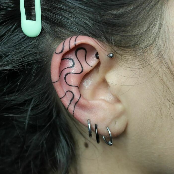 ear tattoo of a freehand wave design