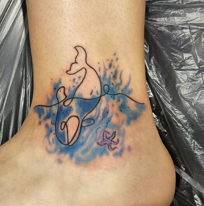 Single line watercolor whale ankle tattoo