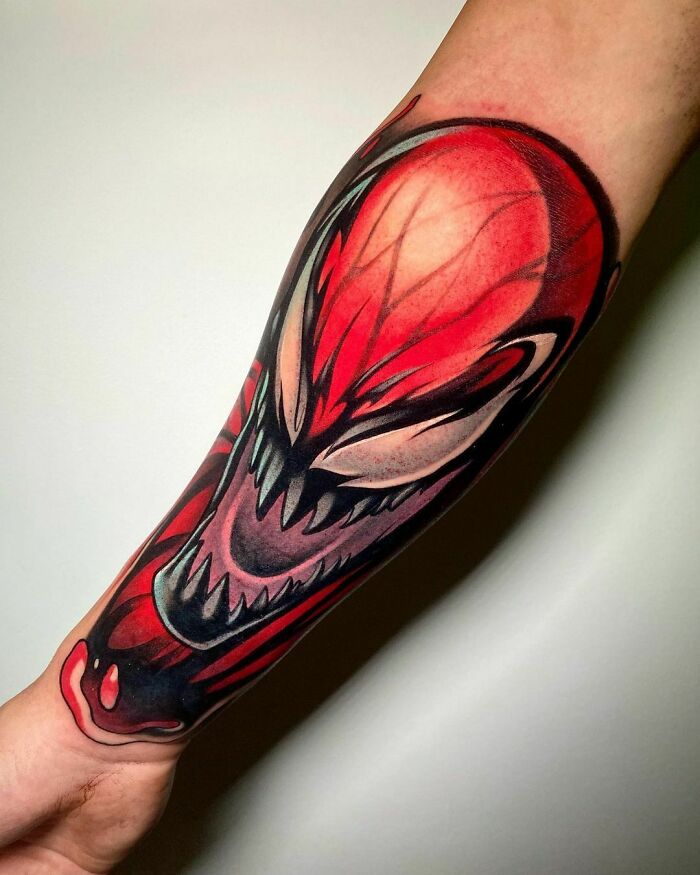 Arm with Marvel tattoo featuring a fierce, detailed design in red and black tones.
