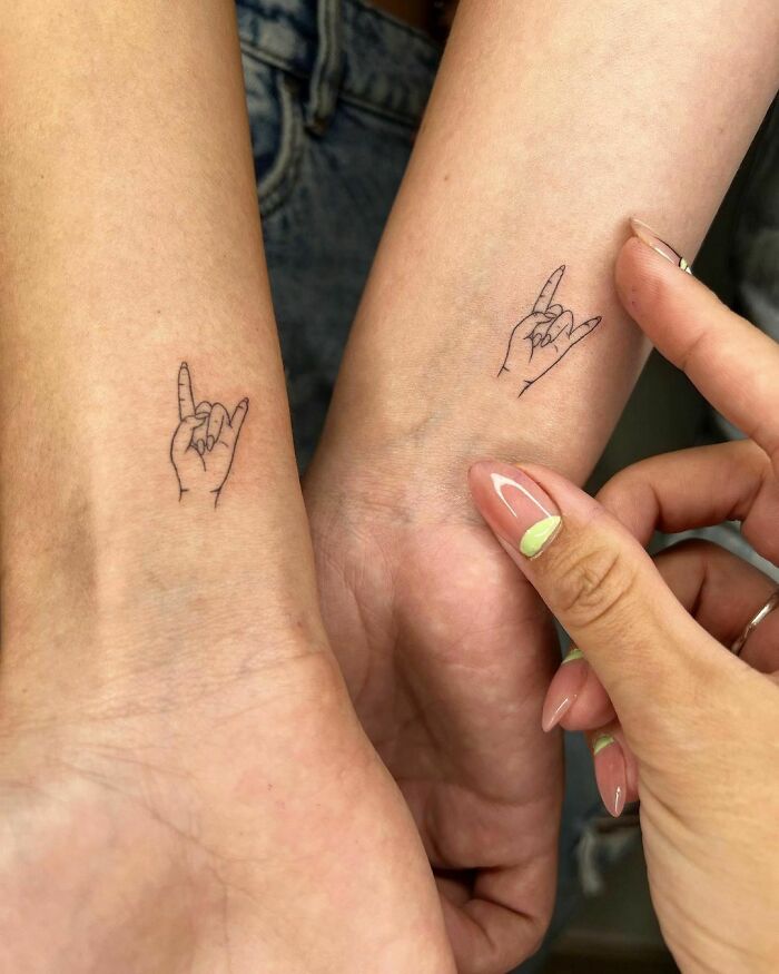 Matching sign of the horns tattoos