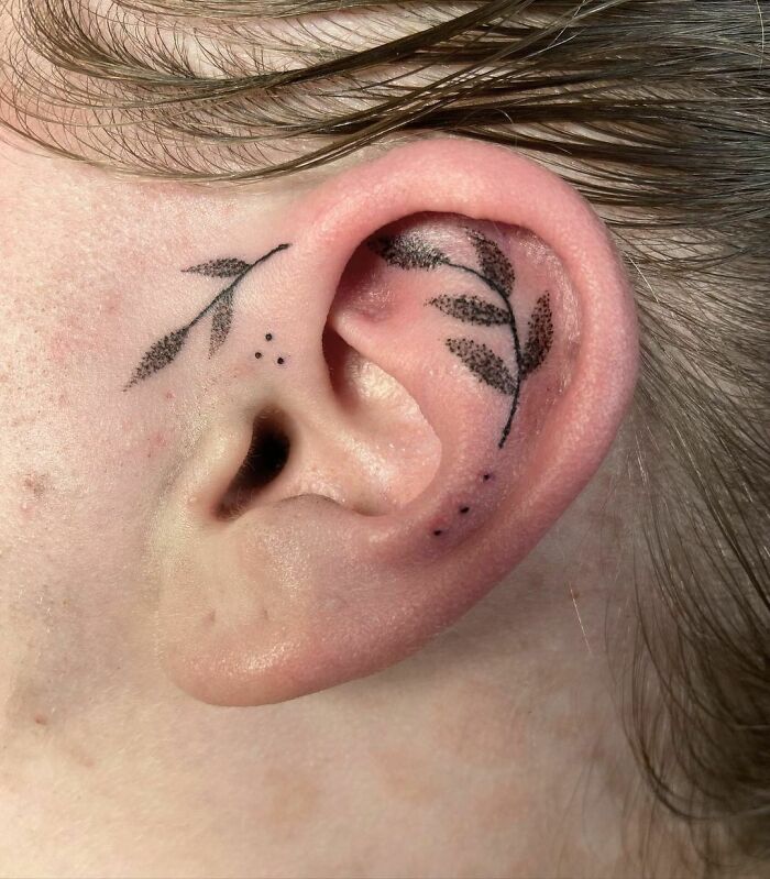 ear tattoo of a leafy stem and dots