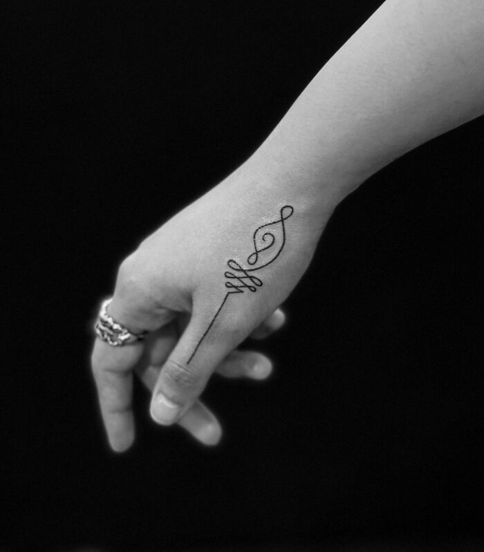 Single line note thumb tattoo