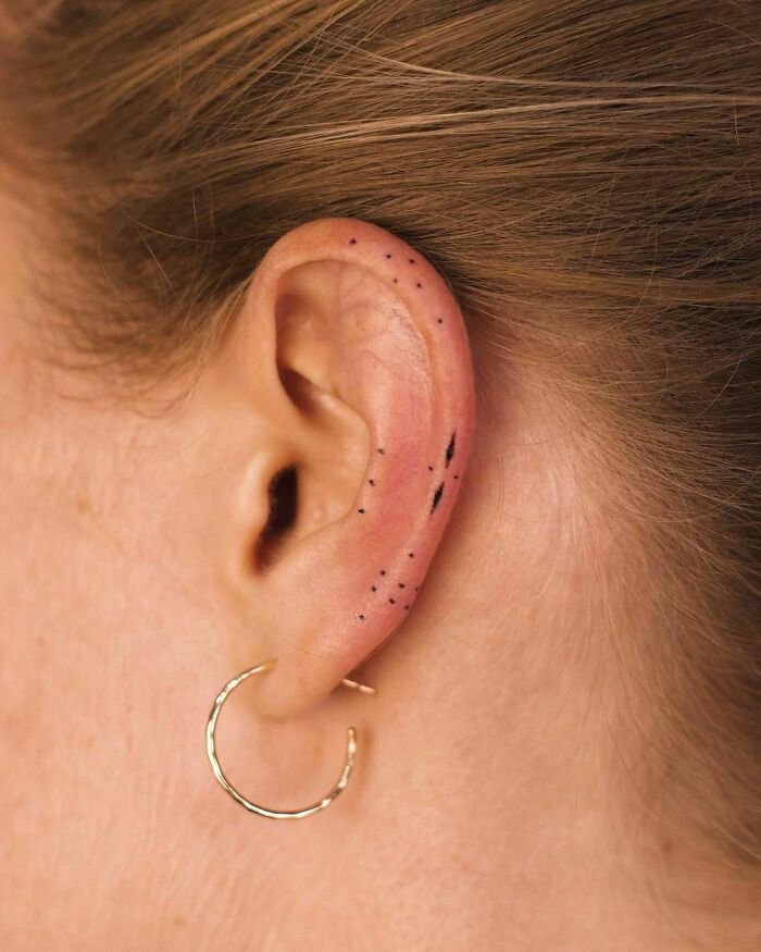 ear tattoo of a minimal line and dot design
