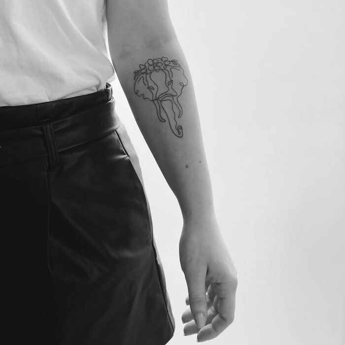 Single line elephant with flowers arm tattoo