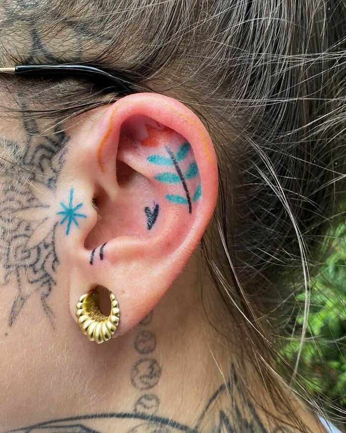 ear tattoo of a heart, star, and leaves
