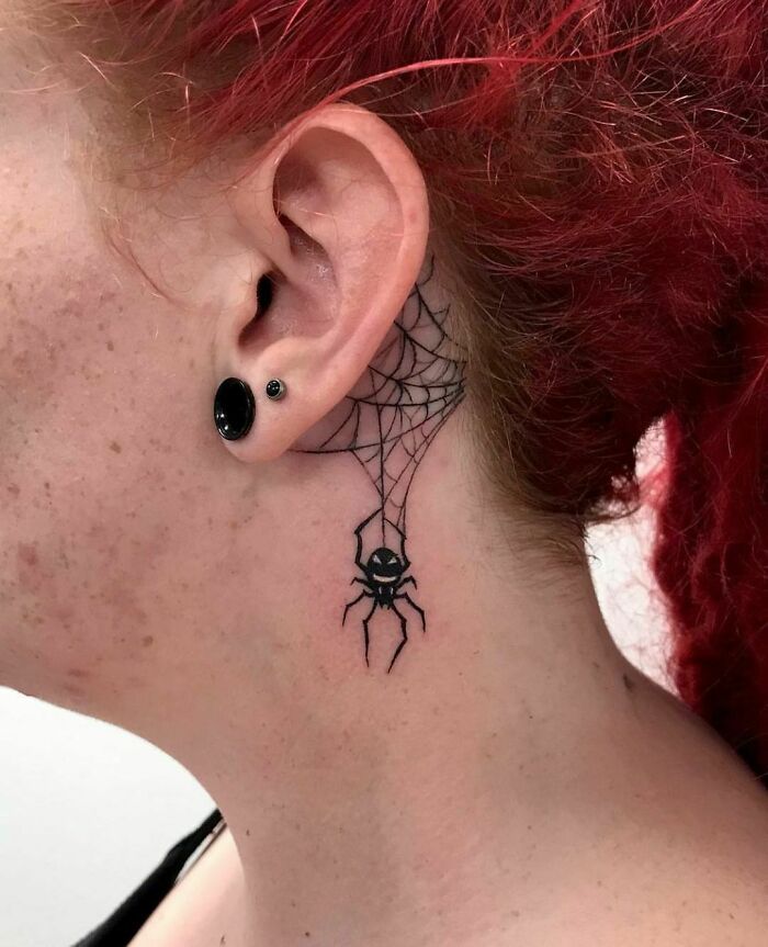 ear tattoo of a spider and a web