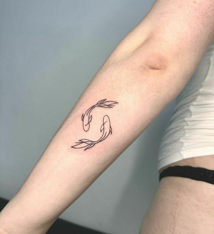 minimalistic tattoo of fishes in harmony sign