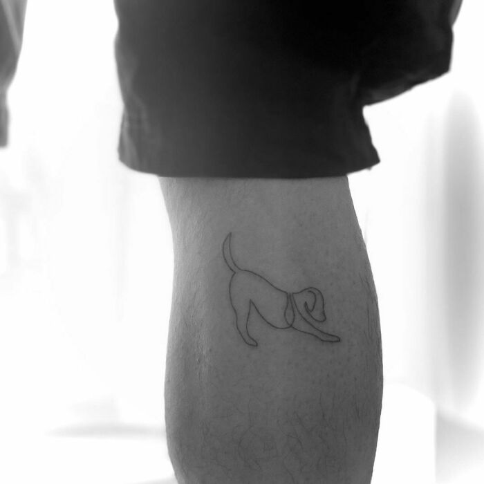 Line dog stretching leg tattoo