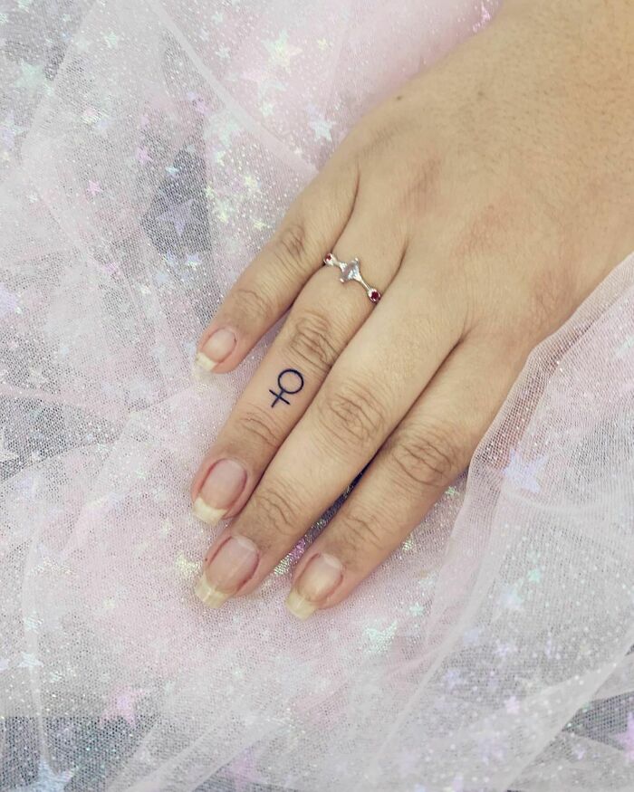 minimalistic tattoo of the female symbol