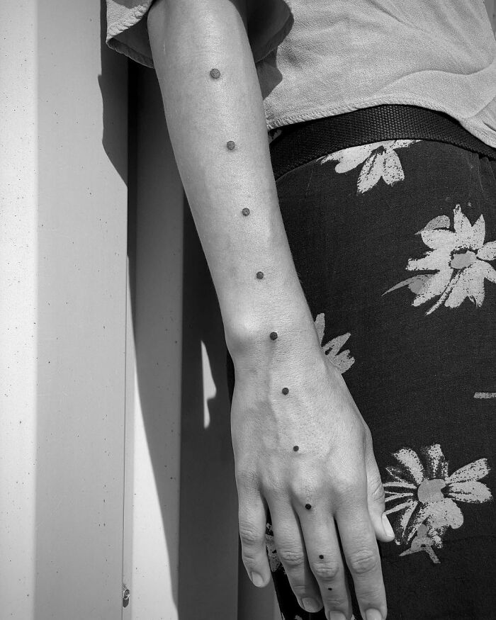 minimalistic tattoo of dots from forearm to palm