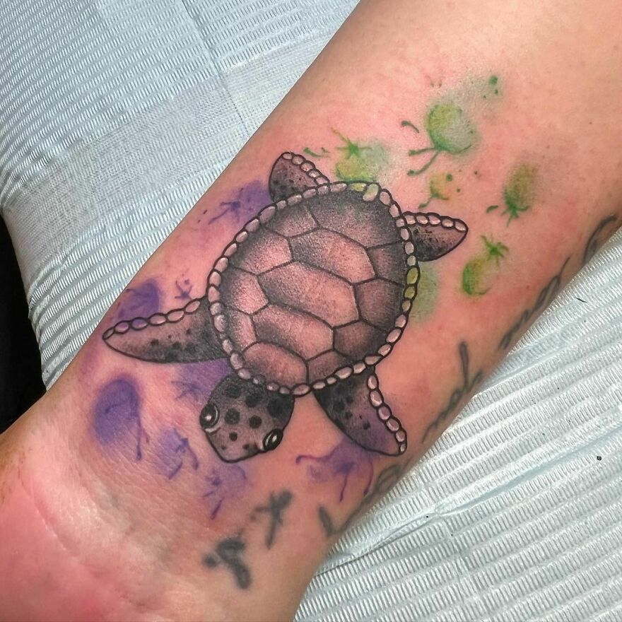 Watercolor turtle tattoo on the forearm