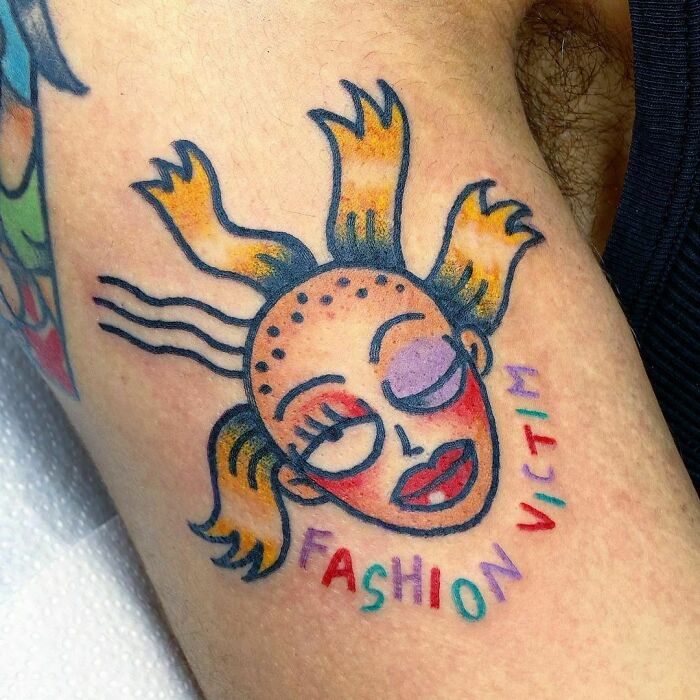 Cynthia from Rugrats and 'Fashion Victim' script under tattoo