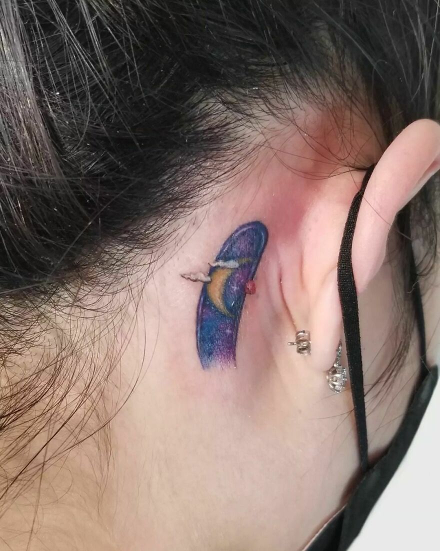 night sky with clouds and moon tattoo behind the ear