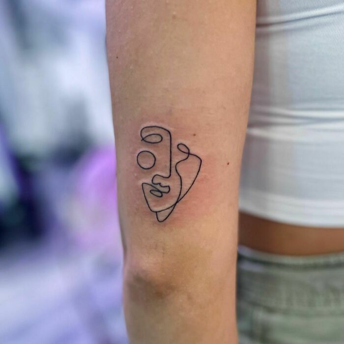 Single line abstract face arm tattoo