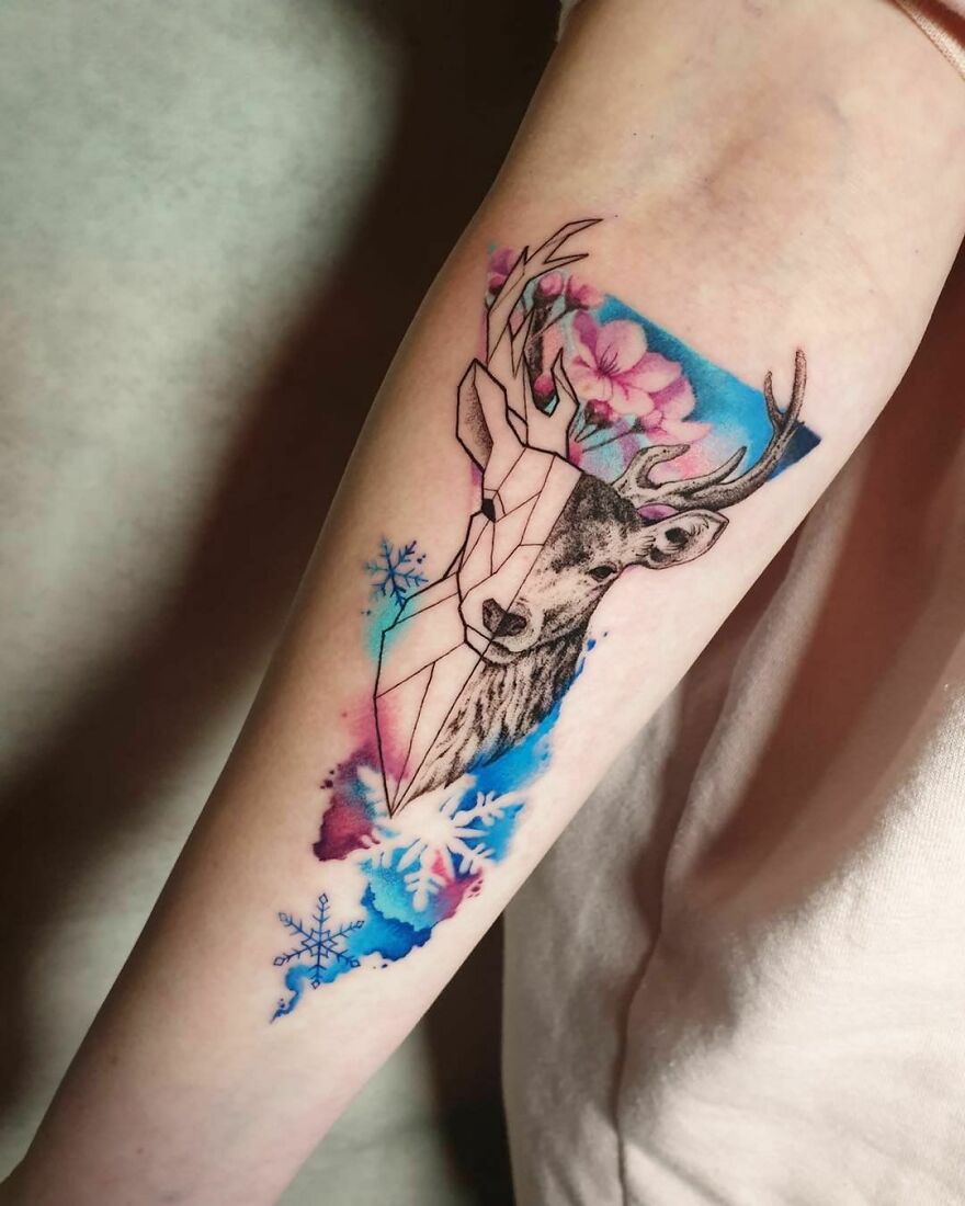 colorful abstract deer with flowers and snowflakes tattoo on the forearm