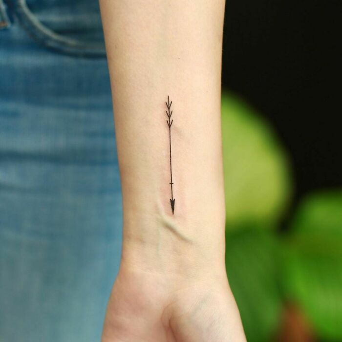 minimalistic tattoo of an arrow