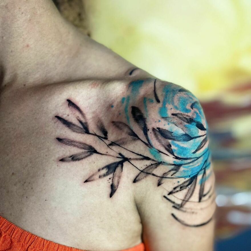 black and blue leaves tattoo on the shoulder