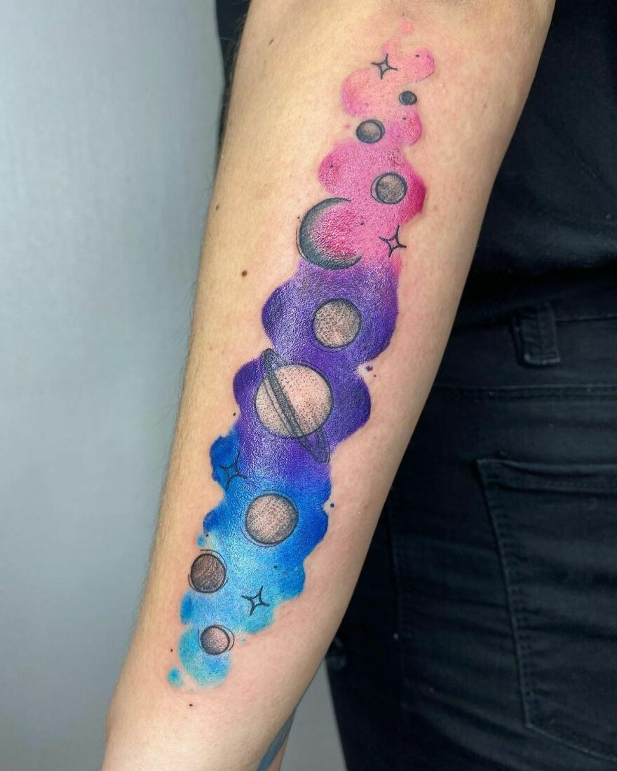 colorful planets tattoo on the forearm