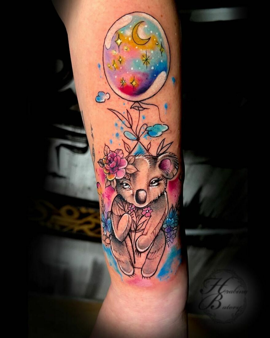 tattoo of colorful koala with a balloon on the arm