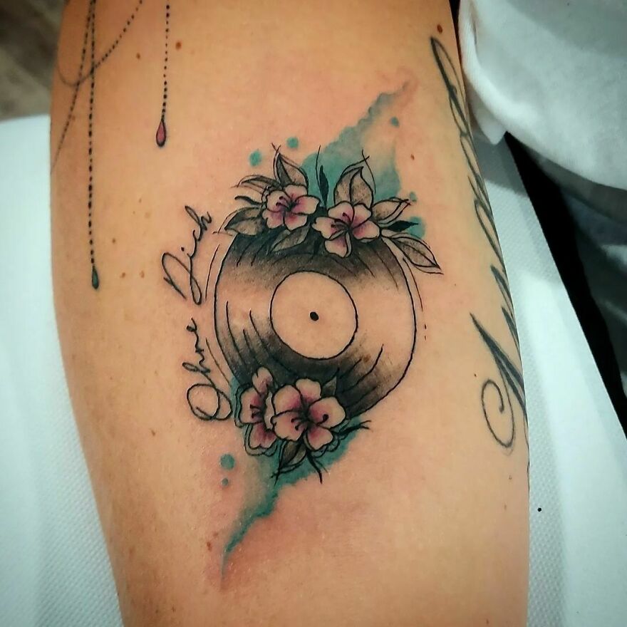vinyl record with flowers tattoo on the arm