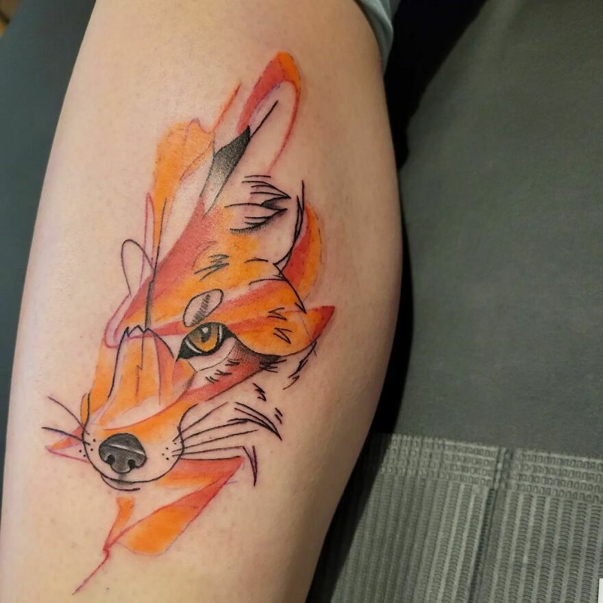 a half of a red fox face tattoo on the leg