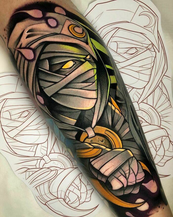 Marvel tattoo of Moon Knight, a mysterious wrapped figure with vibrant colors on an arm.