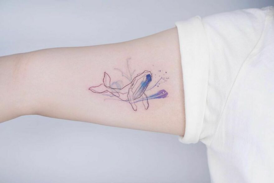 Watercolor whale tattoo on the arm