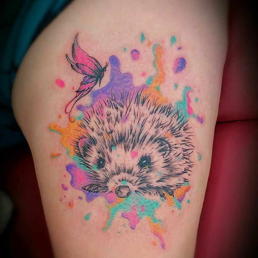 colorful hedgehog and butterfly tattoo on the arm