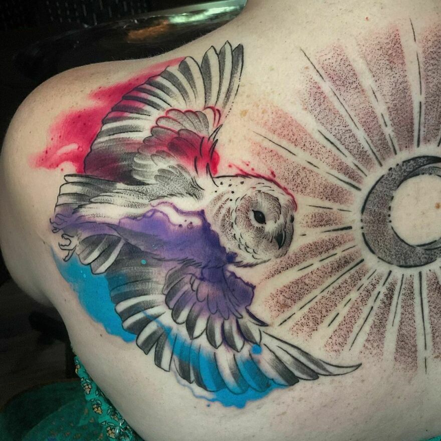 owl flying to the sun colorful tattoo on the back