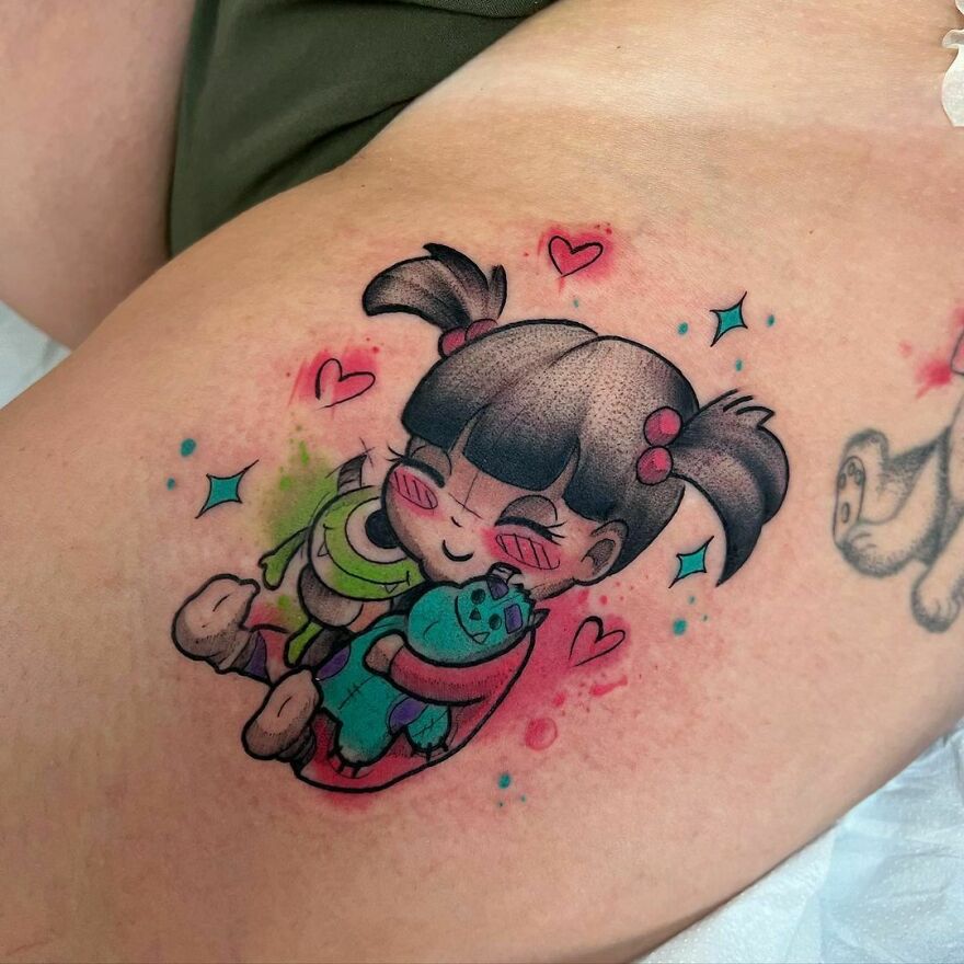 little girl with toys monsters in her hands tattoo on the leg