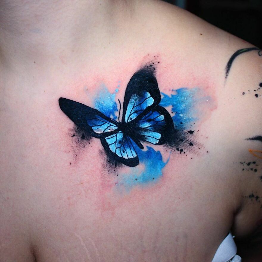 blue and black butterfly tattoo on the chest