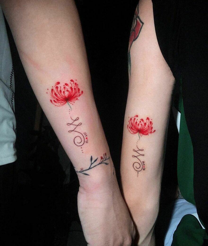 flowers with a sign tattoos on the arms