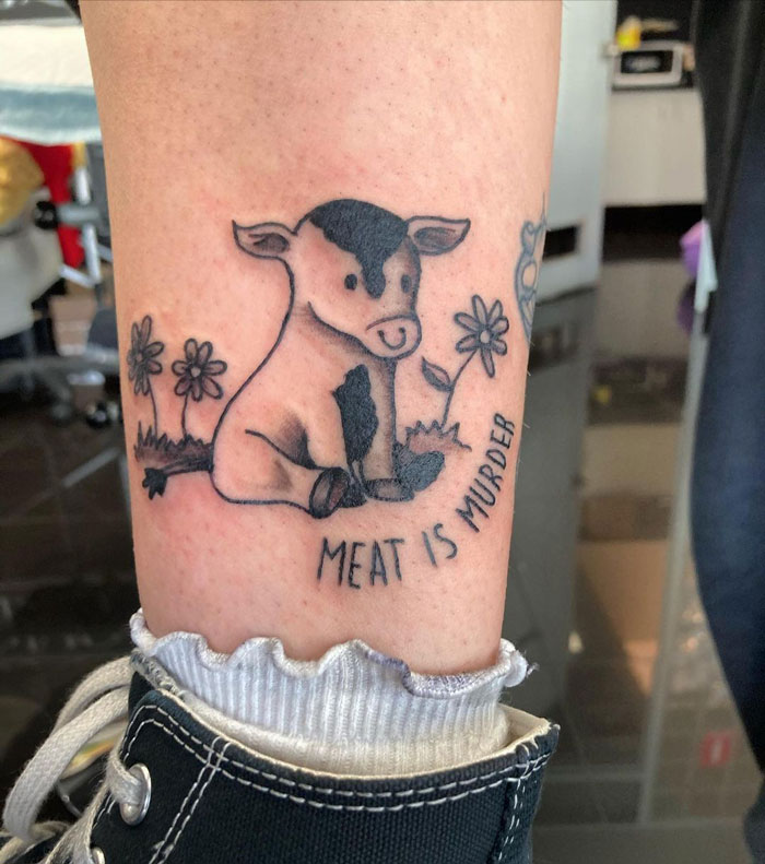 Little sitting cow tattoo on leg