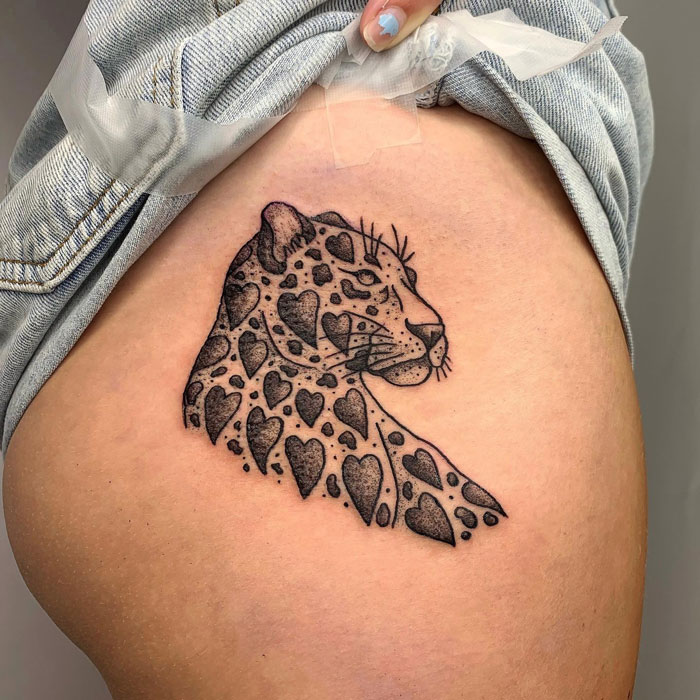 Leopard with hearts as fur spots tattoo on leg