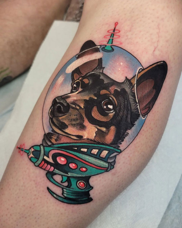 Animal tattoo of a dog in a colorful space helmet on skin.