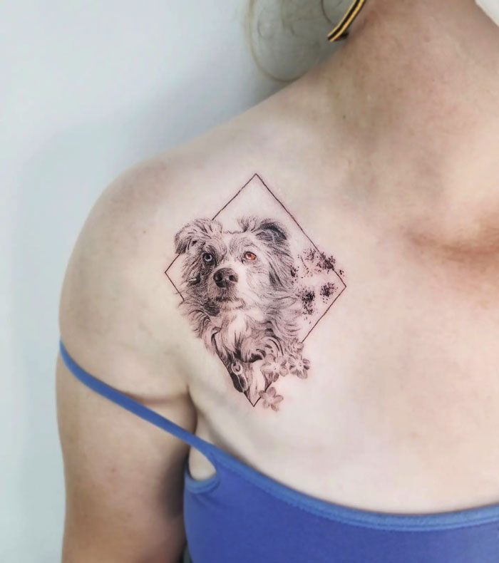 A detailed dog tattoo design on a person's shoulder, showcasing animal tattoo artistry.